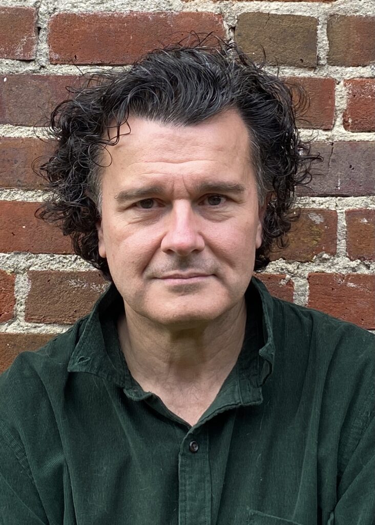 Headshot of Gerard Logan, against a brick wall.